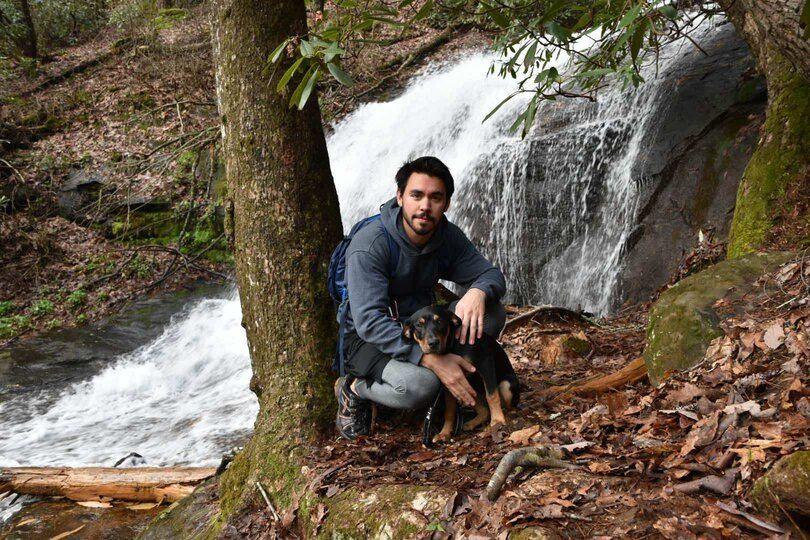 Stephen in front of a cascade with his dog