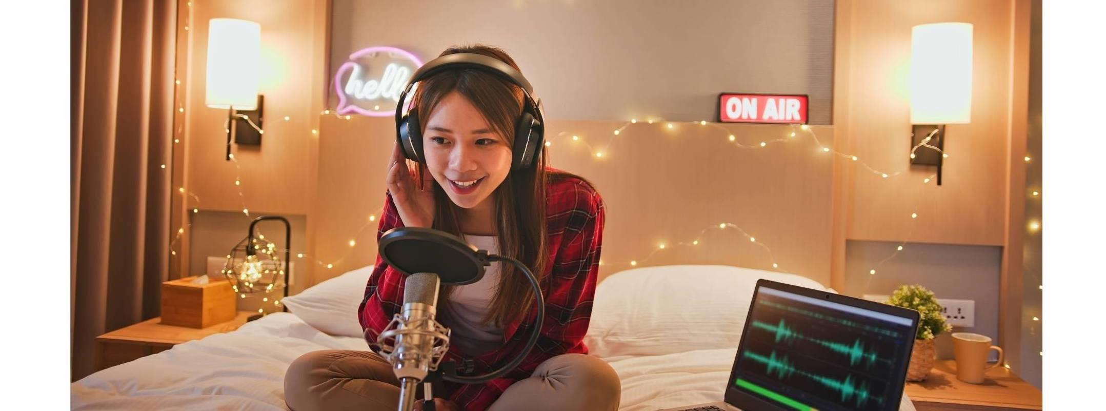 asian teenage girl recording a podcast in her bedroom