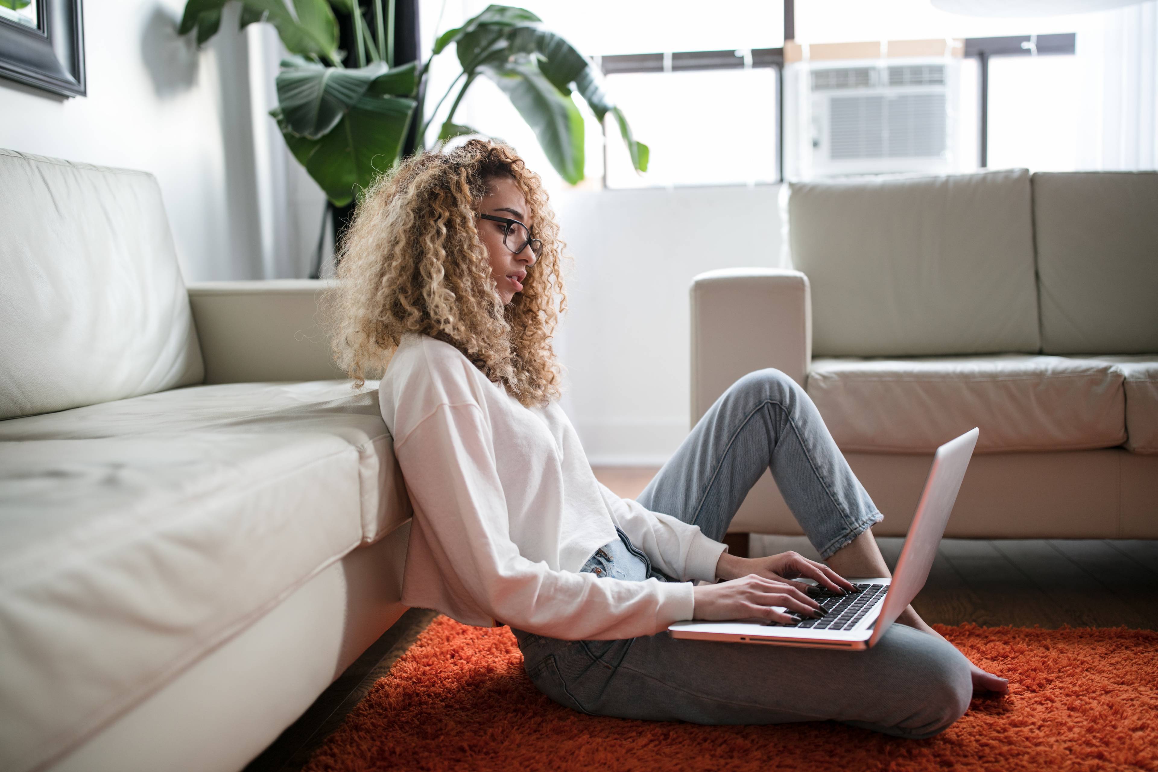 woman sitting on the floor typing on a computer