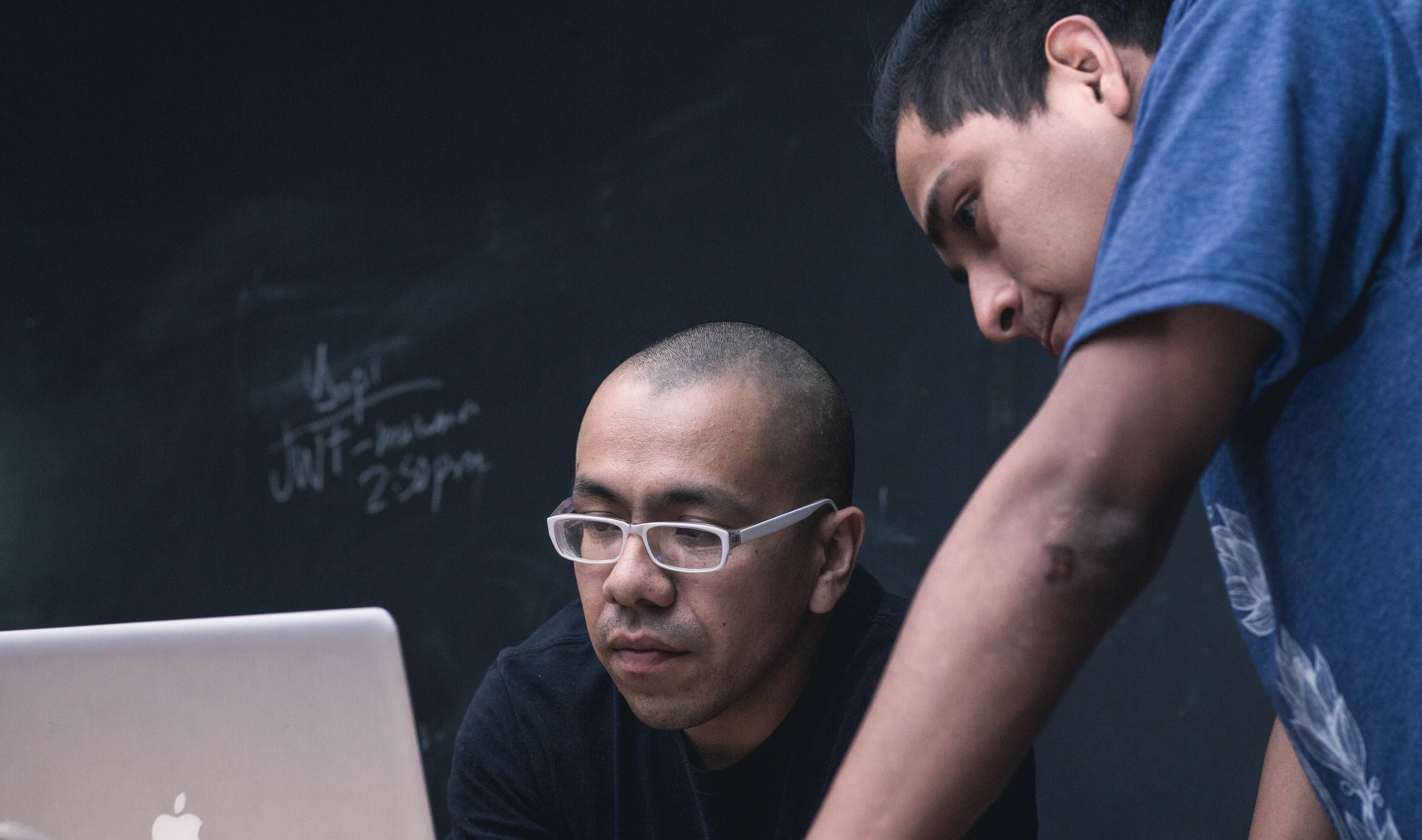 two students looking at an apple laptop