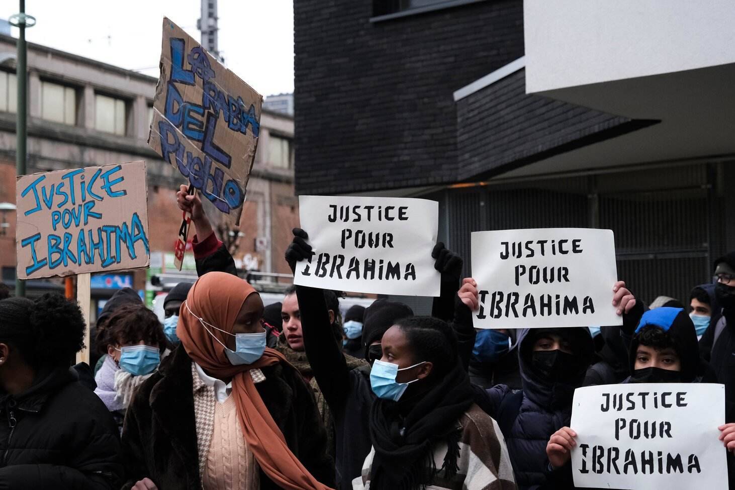 Multiple people holding signs of protest. high school research project francophone