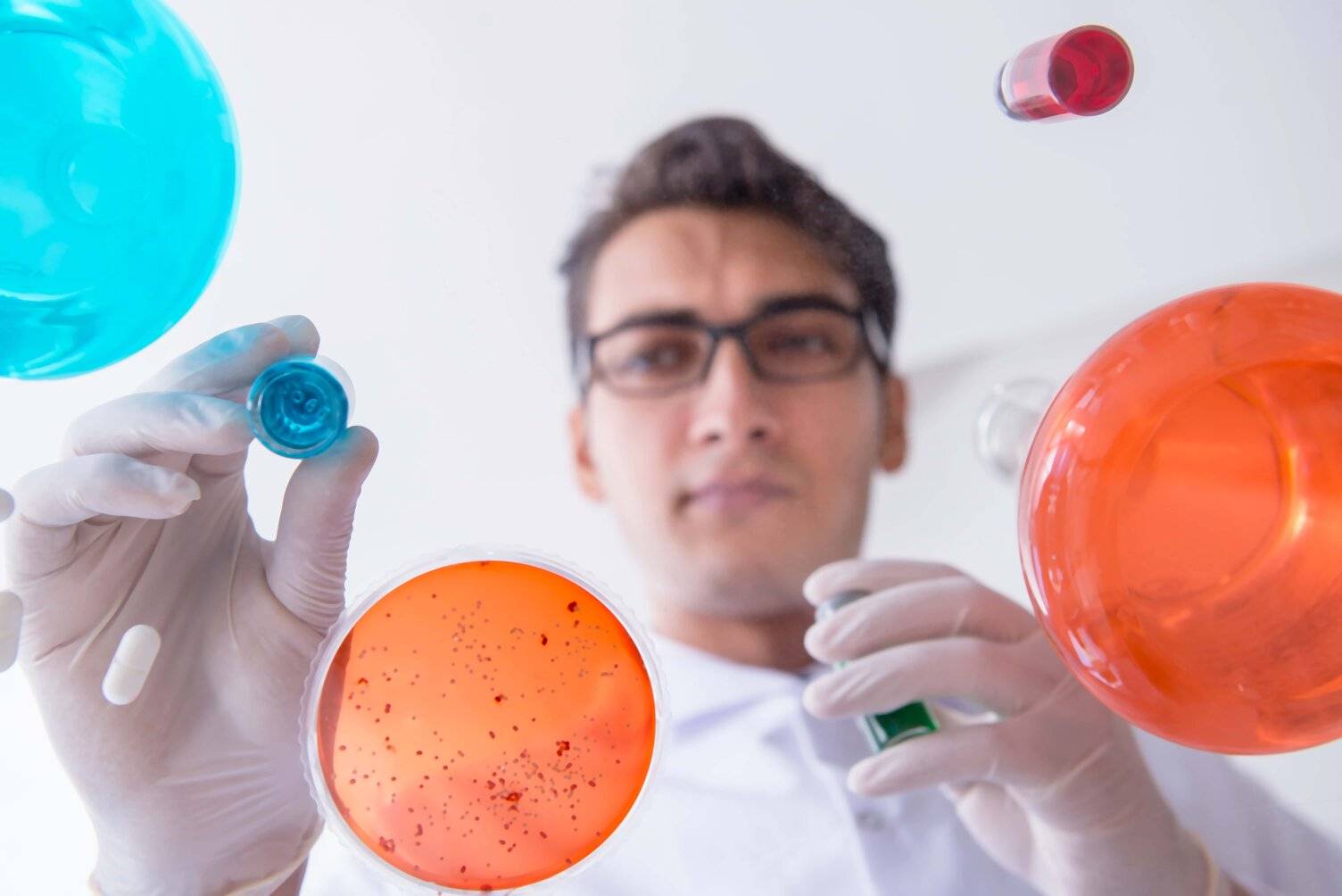 Student with gloves and beakers high school research