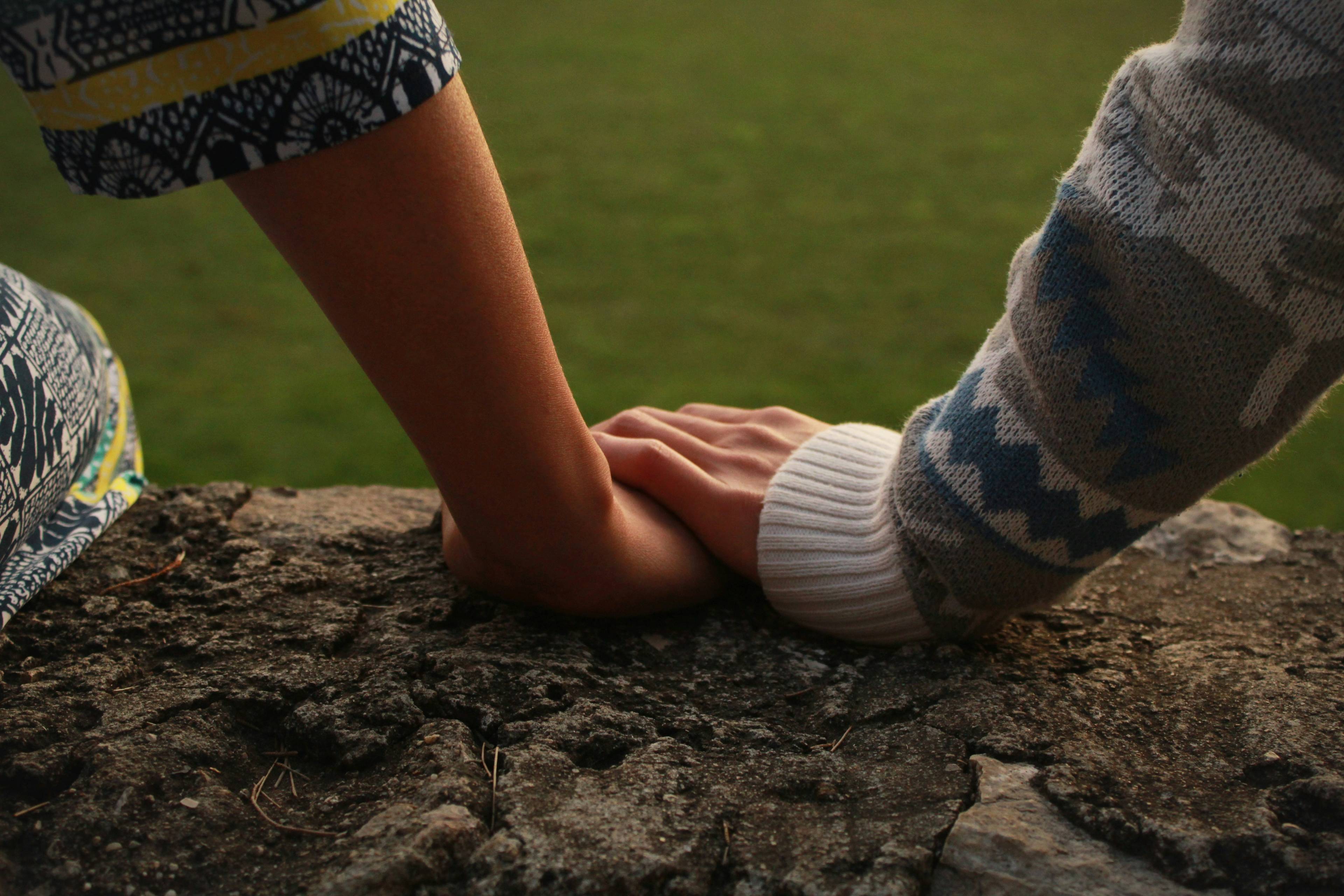 hands holding each other on a rock