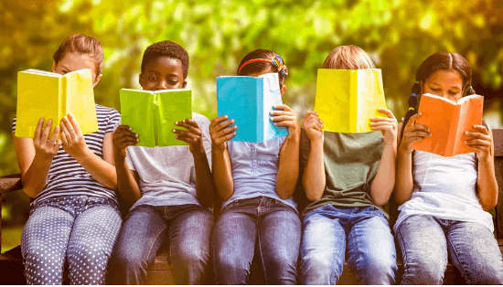 Five children sit on a bench, reading books. 