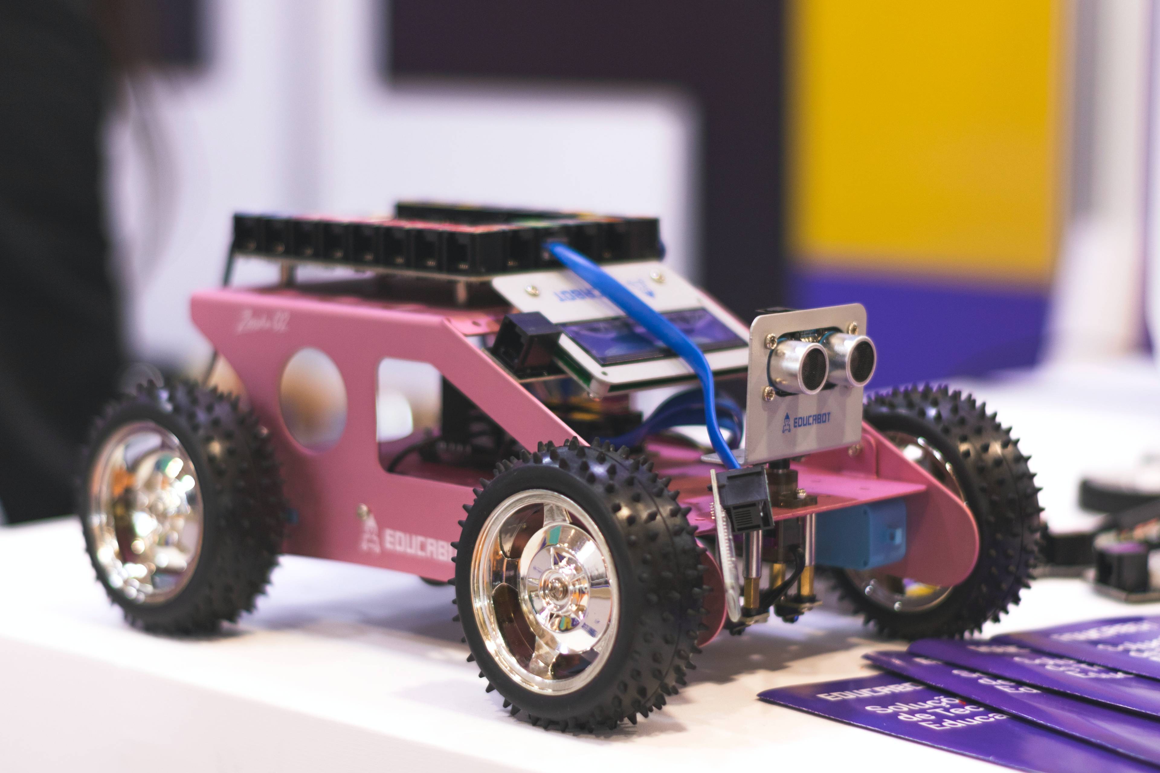 a pink robot car with spikey wheels