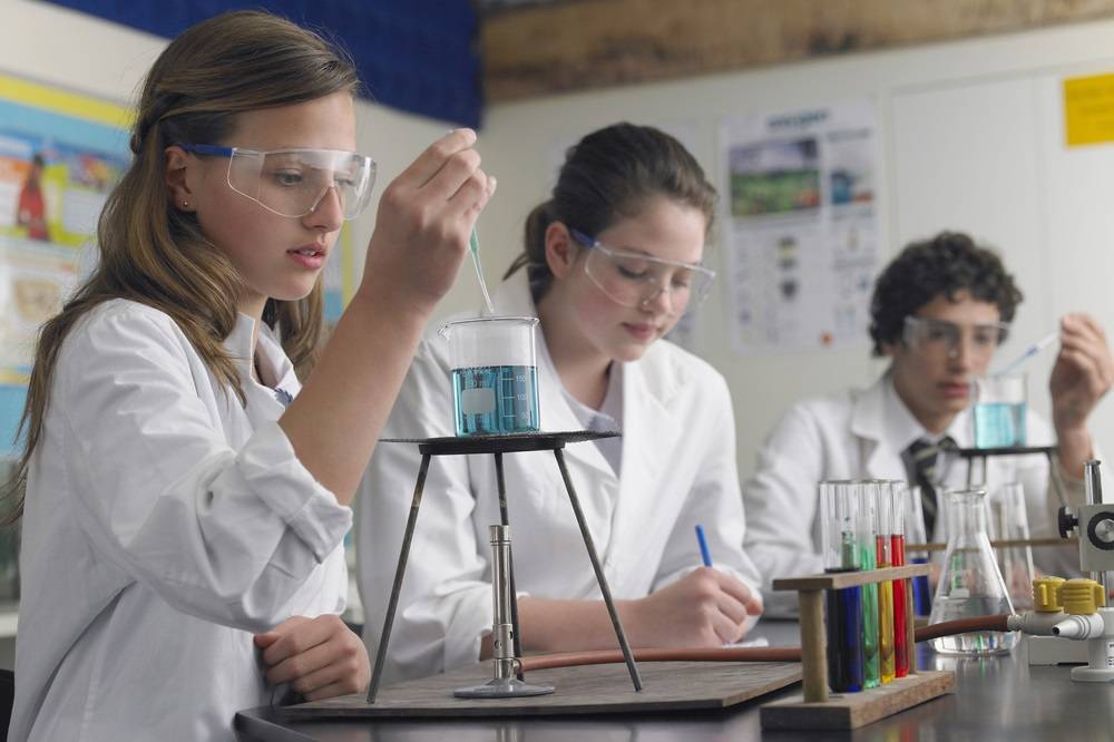 Teenage students caring out experiments in chemistry class
