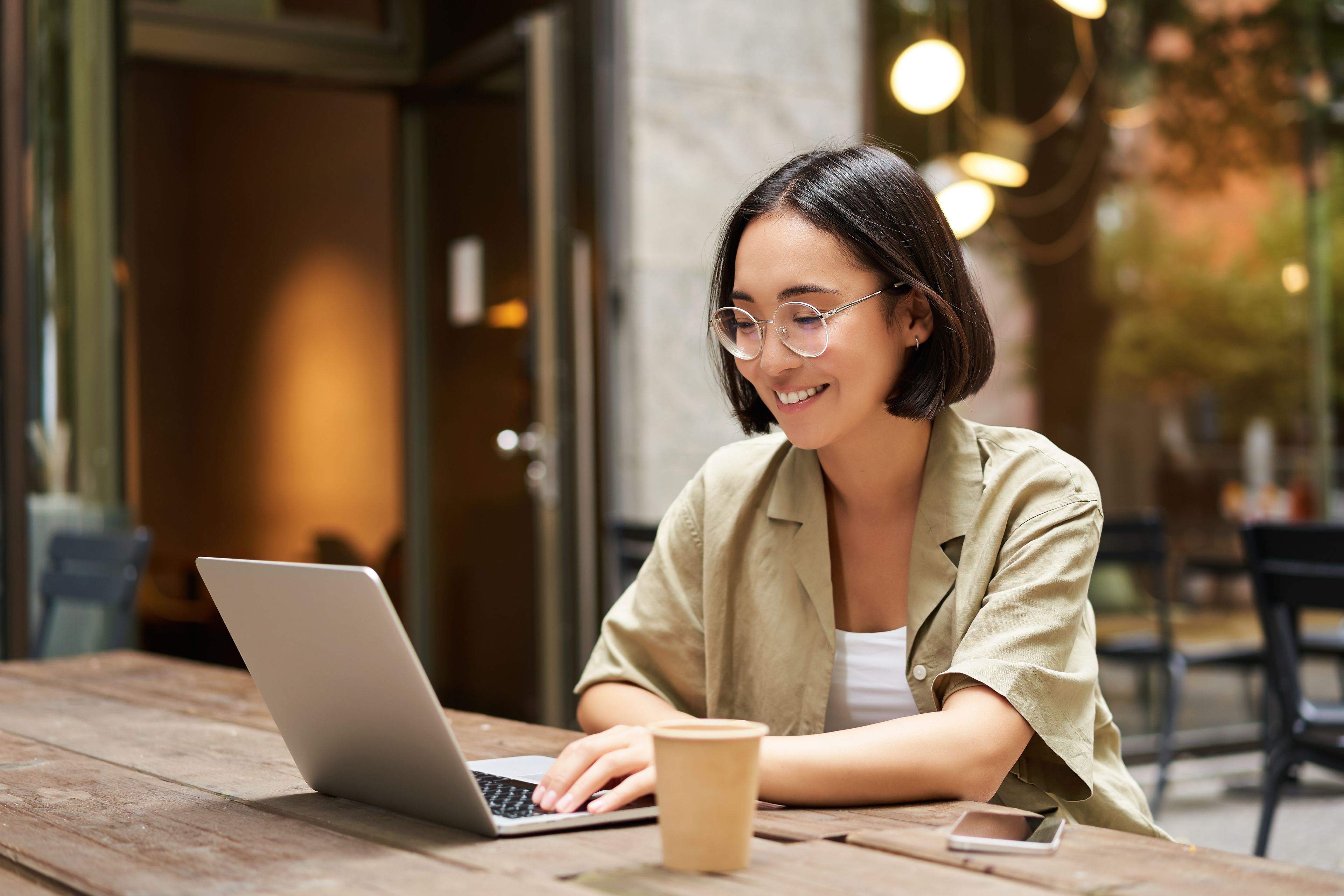 Young motivated student sitting on an online meeting in front of her laptop.